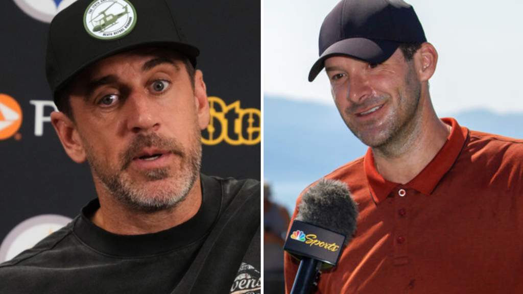 Pemain NFL Aaron Rodgers sedang mengenakan seragam tim di pinggir lapangan dalam sesi latihan pramusim.