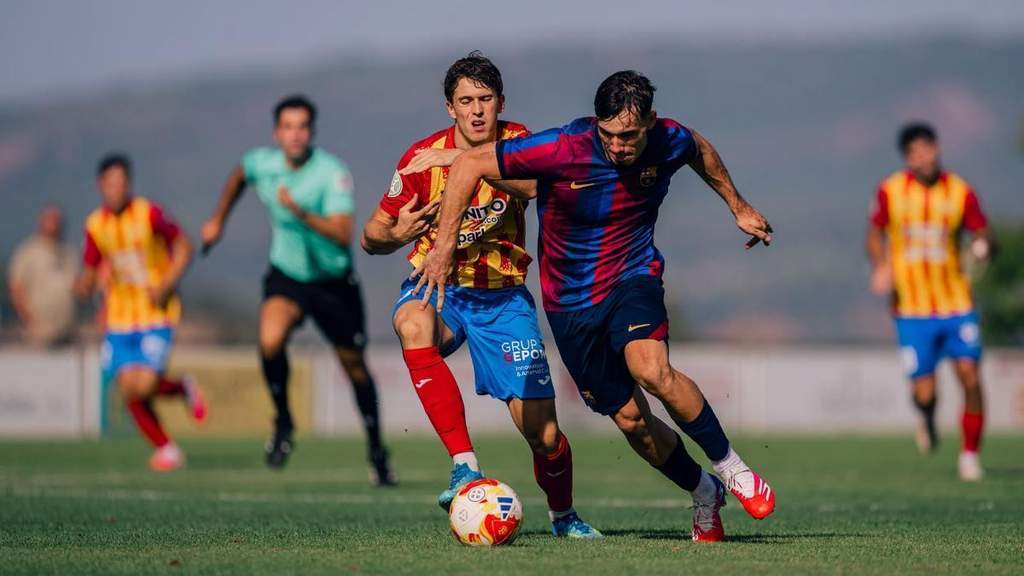 Pemain Barca Atletic Ignasi Quer berduel merebut bola dalam laga uji coba pramusim melawan UE Tona.