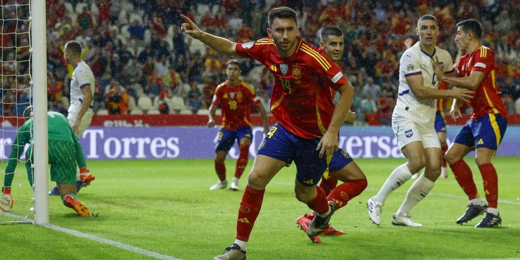 Aymeric Laporte mengenakan jersey tim nasional Spanyol saat berlatih di lapangan hijau dengan ekspresi fokus.