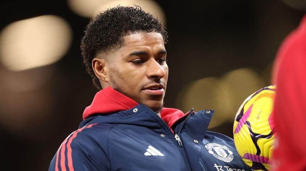 Marcus Rashford mengenakan jersey latihan dengan fokus penuh saat bersiap menghadapi sesi latihan bersama rekan setimnya.