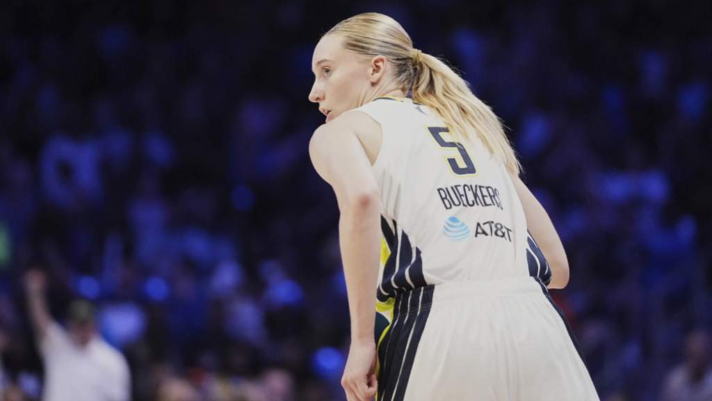 Pebasket Dallas Wings Paige Bueckers sedang memegang bola di lapangan dalam pertandingan WNBA musim 2026 dengan jersey tim.