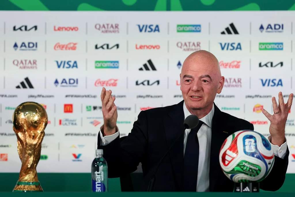 Gianni Infantino selaku Presiden FIFA saat menghadiri konferensi pers di markas besar FIFA dengan latar belakang logo organisasi sepak bola dunia.